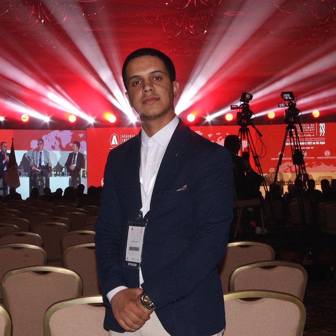 Benraya Aymen in a navy blazer at a business conference in Algiers